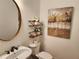Charming powder room with modern fixtures, decorative shelves, and stylish artwork at 1105 River Laurel Dr, Suwanee, GA 30024