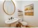Elegant powder room with pedestal sink, gold accents, and decorative art creating a warm ambiance at 1105 River Laurel Dr, Suwanee, GA 30024