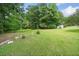 Expansive backyard with lush green grass, mature trees, and a shed, perfect for outdoor activities at 180 Butterfield Ln, Fayetteville, GA 30214