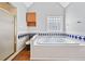 Bathroom featuring a tiled whirlpool tub, glass shower, and a decorative window at 180 Butterfield Ln, Fayetteville, GA 30214