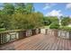 Wide plank wood deck framed with decorative brown and white lattice railing in a backyard with trees at 180 Butterfield Ln, Fayetteville, GA 30214