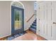 Welcoming foyer with a decorative blue front door, hardwood floors, and a staircase leading to the upper level at 180 Butterfield Ln, Fayetteville, GA 30214