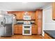 Functional kitchen with stainless steel appliances, granite countertops, and wood cabinetry at 180 Butterfield Ln, Fayetteville, GA 30214
