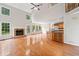 Bright, open living room featuring a stone fireplace, hardwood floors, and large windows overlooking the backyard at 180 Butterfield Ln, Fayetteville, GA 30214