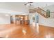 Open-concept living room with hardwood floors, a kitchen island, and a staircase leading to the second floor at 180 Butterfield Ln, Fayetteville, GA 30214
