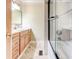 Bathroom featuring vanity with cabinets and a tub with black framed shower doors at 2211 Jonathan Ave, Lithonia, GA 30058