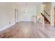 Open-concept living room featuring hardwood floors, a wooden staircase, and neutral wall colors at 2211 Jonathan Ave, Lithonia, GA 30058