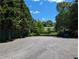 Empty asphalt parking lot bordered by mature trees and landscaping, ideal for various purposes at 395 Russell Sw Dr, Smyrna, GA 30082
