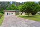 Exterior view showing the house with a spacious cracked driveway and a mature tree at 624 Lyle Se Dr, Marietta, GA 30067
