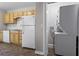 Kitchen with yellow cabinets and white appliances also features a laundry closet with stacked units at 624 Lyle Se Dr, Marietta, GA 30067