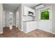 White kitchenette featuring stainless microwave, white cabinets and sink, and a view to the exterior at 624 Lyle Se Dr, Marietta, GA 30067
