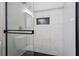 Walk-in shower showcases sleek tilework with black accents, glass enclosure, and convenient niche at 624 Lyle Se Dr, Marietta, GA 30067
