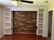 Bedroom featuring built-in shelving, a brick accent wall, and hardwood flooring at 1007 Wayne Dr, Snellville, GA 30078