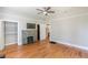 Bright bedroom featuring a stone fireplace, ceiling fan, hardwood floors, closet and doorway to an ensuite bathroom at 1967 West John Calvin Ave, Atlanta, GA 30337