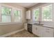 Bright kitchen featuring white cabinets, stainless steel appliances, and granite countertops near double windows at 1967 West John Calvin Ave, Atlanta, GA 30337