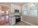 This kitchen showcases white cabinetry, a stainless steel range, granite countertops, and natural light from nearby windows at 1967 West John Calvin Ave, Atlanta, GA 30337