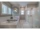 Bathroom featuring a soaking tub under window and glass enclosed shower at 2657 Cedar Pine Way, Atlanta, GA 30360