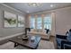 Comfortable living room features plenty of natural light, modern artwork, and a plush sofa and chairs at 2657 Cedar Pine Way, Atlanta, GA 30360