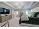Spacious main bedroom features tray ceiling, chandelier, flat screen TV, and luxurious textures and tones at 2657 Cedar Pine Way, Atlanta, GA 30360