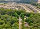 The home has an aerial view of a suburban neighborhood surrounded by lush, mature trees and manicured lawns at 2865 Bryant Ct, Cumming, GA 30040