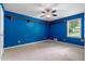 Bright blue carpeted bedroom with a large window and built-in shelving at 2865 Bryant Ct, Cumming, GA 30040