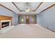Large living room with fireplace, neutral carpet, tray ceilings, and natural light from the doorway at 2865 Bryant Ct, Cumming, GA 30040