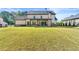 Rear exterior view of home featuring a manicured lawn and covered patio at 704 Rock Springs Rd, Lawrenceville, GA 30043