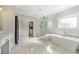 Bathroom featuring glass shower, soaking tub, and closet access at 704 Rock Springs Rd, Lawrenceville, GA 30043