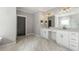 Large bathroom with double vanity, marble floors, and dark gray interior doors at 704 Rock Springs Rd, Lawrenceville, GA 30043