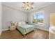 Bright bedroom features hardwood floors, a ceiling fan, and a window with a view of the backyard at 704 Rock Springs Rd, Lawrenceville, GA 30043