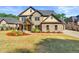 Beautiful two-story brick home featuring manicured lawn and inviting front porch with stone and cedar accents at 704 Rock Springs Rd, Lawrenceville, GA 30043
