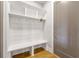 Clean mudroom features wood accent wall, bench, cubbies, and hooks provide storage and organization next to door at 704 Rock Springs Rd, Lawrenceville, GA 30043