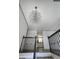 Elegant entryway featuring a chandelier and modern railings, offering a glimpse into the kitchen at 710 Singing Hills Ct, Roswell, GA 30076