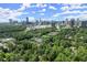 Aerial view of a green suburban neighborhood near a vibrant city skyline on a sunny day at 1050 Shady Valley Pl, Atlanta, GA 30324