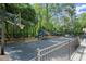 Community basketball court featuring a blacktop and basketball hoop surrounded by a black metal fence and green trees at 1050 Shady Valley Pl, Atlanta, GA 30324