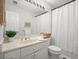 Well-lit bathroom with a white vanity, toilet, and shower featuring a patterned shower curtain at 1050 Shady Valley Pl, Atlanta, GA 30324