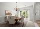 Inviting dining room with chandelier, stylish chairs, and bright window for natural light overlooking the front yard at 1050 Shady Valley Pl, Atlanta, GA 30324