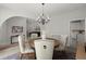 Elegant dining room featuring a round table, upholstered chairs, modern chandelier, and open access to the living room and kitchen at 1050 Shady Valley Pl, Atlanta, GA 30324
