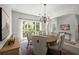 Bright dining room with stylish chandelier, comfortable chairs, and large window offering natural light and green views at 1050 Shady Valley Pl, Atlanta, GA 30324