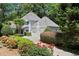 Charming home with a well-manicured front yard, beautiful landscaping, and a gray driveway leading to a two-car garage at 1050 Shady Valley Pl, Atlanta, GA 30324