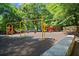 Community playground featuring swings, slides, climbing structure and soft rubber ground covering, surrounded by trees at 1050 Shady Valley Pl, Atlanta, GA 30324