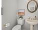 Cozy powder room featuring a pedestal sink, oval mirror, decorative artwork, and classic fixtures adding a touch of elegance at 1050 Shady Valley Pl, Atlanta, GA 30324