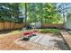 This backyard showcases a cozy seating area, lush greenery, wooden fence and a storage shed at 2272 Desmond Dr, Decatur, GA 30033