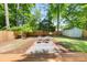 The backyard features a charming seating area, lush greenery, a wooden fence, and a storage shed at 2272 Desmond Dr, Decatur, GA 30033