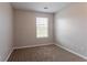 This bedroom offers neutral walls, carpet flooring, and a window allowing for natural light to fill the room at 4544 Parkview Sq, Atlanta, GA 30349