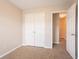 This bedroom offers neutral walls, carpet flooring, a closet, and an entrance leading to another room at 4544 Parkview Sq, Atlanta, GA 30349