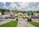 Charming townhome complex featuring assigned parking, lush trees, and a blue sky with fluffy white clouds at 4544 Parkview Sq, Atlanta, GA 30349