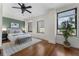 Bedroom featuring hardwood floors, a decorative ceiling fan, and large windows with city views at 75 Ponce De Leon Ave # 701, Atlanta, GA 30308