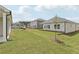 A grassy backyard with views of the home's exterior and other homes in the neighborhood at 7760 Sheffield Ter, Fairburn, GA 30213