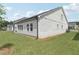 Exterior side and rear view of home with a large lawn and patio at 7760 Sheffield Ter, Fairburn, GA 30213